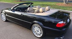 a black convertible car parked in a parking lot