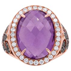 A beautiful oval shaped purple amethyst captivates the soul of this once-in-a-lifetime ring. Sitting as the central motif, the gemstone is 18x13mm in size and rests delicately on luxurious 18k rose gold. The gemstone is flanked by a circular design of natural, white round-cut diamonds. The beauty of the stone is only matched by the art-deco design of the band, intricately crafted with champagne color diamonds. The total diamond weight of this piece is 1.00 c.t. Amethyst is treated for an extra l Purple Amethyst Ring, Amethyst And Diamond Ring, Diamond Cocktail Ring, Circular Design, Color Champagne, Diamond Cocktail Rings, Champagne Diamond, Champagne Color, Amethyst Stone