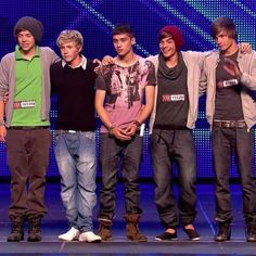 several young men are standing together on stage