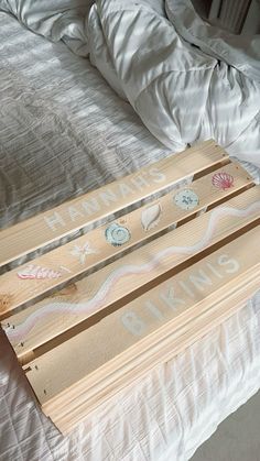 a wooden sign sitting on top of a bed