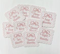 five month stickers with pink bows and the words three month, nine months on them