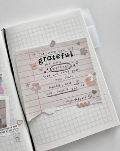 an open notebook with paper and stickers on the pages that say grateful, i love you