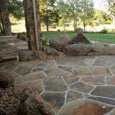 an outdoor patio with stone steps leading to a fire pit in the middle of it