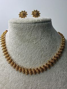 This exquisite piece of craftsmanship comes from our Traditional collection. Finish: 24 grams gold finish Necklace Fastening: Adjustable Dori Earring Fastening: Push Back Contains: 1 necklace, 1 pair of earrings Indian Necklace Gold, Traditional Gold Necklace, Antique Gold Necklace, Temple Jewelry Necklace, Gold Necklace Indian, Asian Jewelry, Temple Jewelry, South Indian Jewelry, Indian Necklace