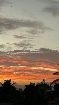 an orange and pink sunset with palm trees in the foreground, clouds in the background