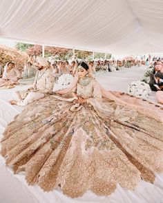 the bride and groom are sitting on their wedding day in front of an enormous group of people