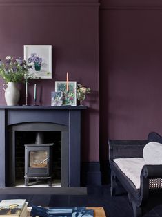 a living room filled with furniture and a fire place in front of a purple wall