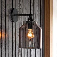 a light that is on the side of a wooden wall next to a lamp fixture