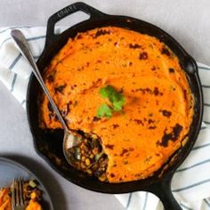 a skillet filled with mashed sweet potatoes and garnished with cilantro