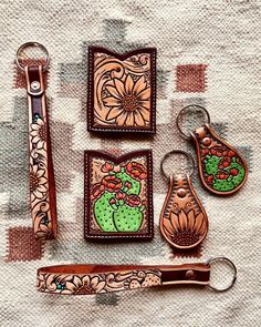 an assortment of leather items are displayed on a table cloth, including scissors and keychains