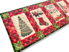 a quilted table runner with christmas stockings and stockings on it