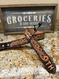 a cross with an orange and black design is sitting on top of a granite counter