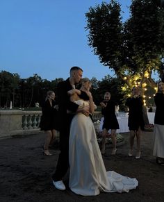 a bride and groom are hugging in the evening