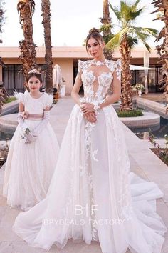 two women in white dresses standing next to each other on a sidewalk with palm trees