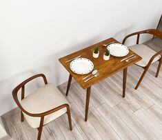 two chairs and a table with plates on it