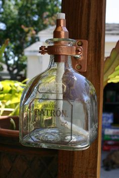 an old fashioned glass bottle hanging from a wooden pole