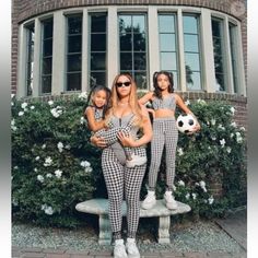 two girls in matching outfits standing next to each other with soccer balls on their hands