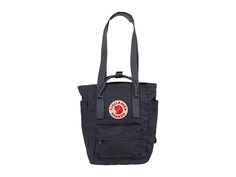 Fjallraven Kanken Totepack Mini - Tote Handbags : Graphite : The Fjällräven Kånken Totepack Mini is a smaller commute option to take anywhere, transforming from a tote, to a backpack with ease when changing commute options or walking around the local grocer. Waterproof G-1000 HeavyDuty Eco S fabrication keeps your stuff dry all-day long. Main compartment can hold all your daily essentials. Interior lined with a padded base for tablets. Zippered top main compartment opening. Front zippered compar Kanken Totepack Mini, Fjallraven Kanken Totepack, Kanken Totepack, Fjallraven Mini, Mini Shopping Bag, Fjällräven Kånken, Zipper Top, Mini Tote, Daily Essentials