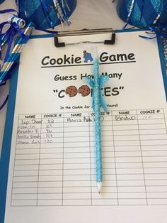 a cookie game is displayed on a clipboard next to blue streamers and candy