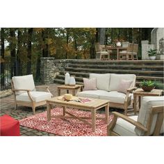 a living room filled with furniture on top of a brick floor covered in red and white rugs