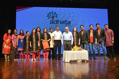 a group of people standing on a stage in front of a screen with the words adhata written on it