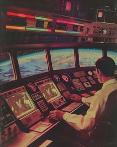 a man is sitting in the cockpit of a space shuttle looking out at the earth