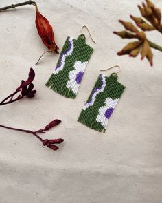 Handwoven beaded earrings in a flat stitch , shade of olive green and white daisies Green Beaded Earrings As A Spring Gift, Green Handwoven Summer Earrings, Handmade White Beaded Earrings For Spring, Artisan Green Handwoven Beaded Earrings, Handmade Green Beaded Flower Earrings, Handmade Green Flower Beaded Earrings, Adjustable Handwoven Green Beaded Earrings, Handmade Green Beaded Earrings For Spring, Green Beaded Earrings For Crafting In Summer