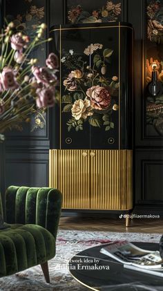 a green velvet chair sitting in front of a black cabinet with gold trim and flowers on it