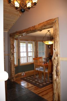 a dining room and kitchen area with wood accents