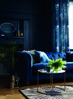 a living room with blue couches and curtains