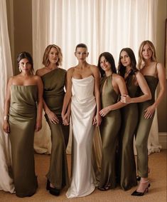 the bridesmaids are posing for a photo in their green and gold gowns