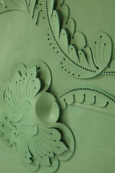 an intricately designed wall with green paint