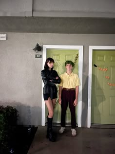 two people standing in front of a green door