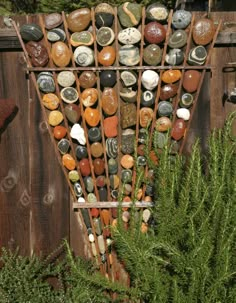 there are many rocks on the side of this wooden fence that is made out of stones