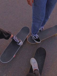 two people standing on their skateboards in the street