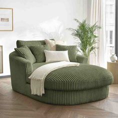 a living room with a large green chair and round ottoman in the middle of it