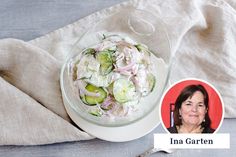 a glass bowl filled with cucumbers and onions on top of a white plate