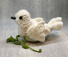 a crocheted white bird sitting on top of a table