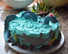 a cake with blue frosting and sea creatures on it sitting on a counter top