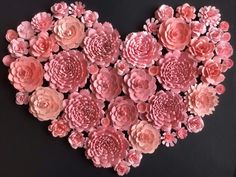 pink paper flowers arranged in the shape of a heart