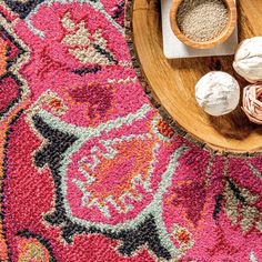 a wooden bowl filled with different types of items on top of a rug