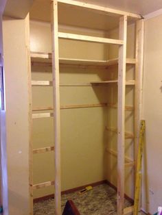 an unfinished closet with shelves and ladders