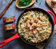 pasta with chicken and mushrooms in a skillet on a table next to other ingredients