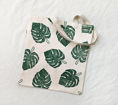 This organic cotton tote bag was printed by hand from hand-carved blocks.  Totes make great gifts! Hot tip: Use this Monstera tote bag as an earth-friendly and practical gift bag--fill it with other small goodies for your favorite plant-loving friend! CARE INSTRUCTIONS: Machine Wash in Cold Water Tumble Dry on Low Heat Iron on Reverse Handmade Green Cotton Canvas Bag, Green Handmade Cotton Canvas Bag, Green Canvas Bag With Eco-friendly Ink As Gift, Eco-friendly Green Bag With Letter Print, Green Eco-friendly Canvas Tote Bag, Everyday Rectangular Bag With Plant Print, Green Eco-friendly Tote Canvas Bag, Toat Bag, Plant Print Tote Bag As Gift