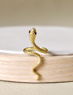 Intertwine yourself in luxury with our Snake Ring. The delicate snake design is expertly crafted with 14k gold plating and rhodium plating, exuding elegance and craftsmanship. Make a statement with this unique and timeless piece that alludes to the exotic and alluring world of the snake. Made in Colombia Adjustable Yellow Gold Elegant Snake Ring, Adjustable Elegant Snake Ring In Yellow Gold, Elegant Adjustable Yellow Gold Snake Ring, Elegant Gold Plated Snake Jewelry, Formal Gold Snake Ring, Adjustable Yellow Gold Snake-shaped Ring, Adjustable Snake Ring In Yellow Gold, Elegant Gold Snake Ring, Elegant Gold Snake Ring With Open Design