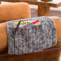 a pair of scissors is sitting in a knitted pouch on a chair next to a coffee table