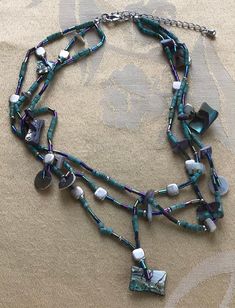 "Featuring this lovely turquoise paua shell and wooden beaded multi-strand necklace. It is adjustable and measures from 16\" to 18\" and has gold tone accents. The necklace is in very good vintage condition and has a silver tone extender." Adjustable Multi-strand Turquoise Necklace With Colorful Beads, Adjustable Multi-strand Turquoise Beaded Necklace, Adjustable Multi-strand Artisan Turquoise Necklace, Turquoise Multi-strand Necklace With Dangling Beads, Artisan Multi-strand Beaded Turquoise Necklace, Adjustable Turquoise Beaded Shell Necklace, Multi-strand Mother Of Pearl Beaded Necklaces, Adjustable Green Beaded Shell Necklace, Bohemian Beaded Abalone Shell Necklaces