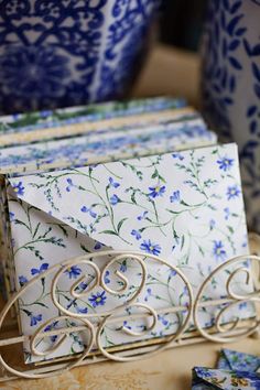 a close up of an envelope on a table with blue and white vases in the background