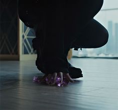 a person kneeling down on the floor with their feet in the air and one hand reaching for something