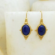 Our Egyptian Revival collection, featuring real lapis cabochons and beads, is inspired by a necklace that was made in the Castellani workshop. In ancient Egypt, lapis was highly regarded as a stone of celestial origin and as a symbol for truth. Materials: lapis cabochon, pewter with gold finish Overall length: 1 1/2" Gift box included From the collection of the Walters Art Museum Artisan Lapis Lazuli Jewelry With Gemstone, Artisan Lapis Lazuli Gemstone Jewelry, Gold Lapis Lazuli Cabochon Jewelry, Gold Lapis Lazuli Jewelry With Cabochon, Traditional Lapis Lazuli Jewelry Gift, Traditional Gold Lapis Lazuli Jewelry, Traditional Gold Jewelry With Lapis Lazuli, Elegant Lapis Lazuli Oval Cabochon Jewelry, Elegant Oval Cabochon Lapis Lazuli Jewelry